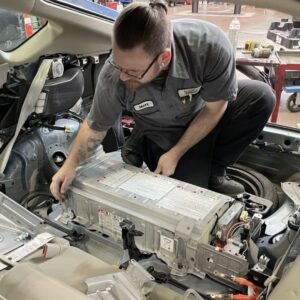 Battery Repair Experts technician installing a replacement hybrid battery pack inside a vehicle