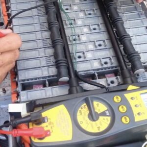 Individual hybrid battery modules being tested with a multimeter during cell revitalization